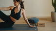 Yoga teacher practicing on the Manduka PROlite yoga mat with the lean cork block and meditation cushion.