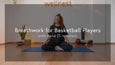 A person sits cross-legged on a yoga mat in a serene room, surrounded by plants and fitness equipment, promoting wellness and tranquility.